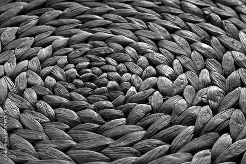 Round straw mat texture in black and white.