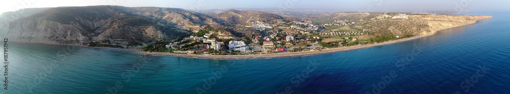 Aerial panoramic view of Pissouri bay, a village settlement between Limassol and Paphos in Cyprus. View of the coastline panorama, beach, hotel, resort, hills, plain and building developments.