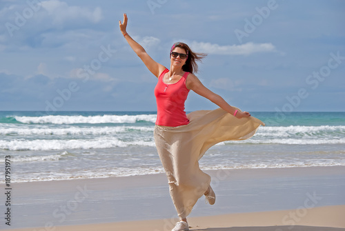 Happy woman walking on the beach