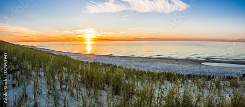 Sandy beach and sunset sky with golden sun shining on white sand  panoramic vista
