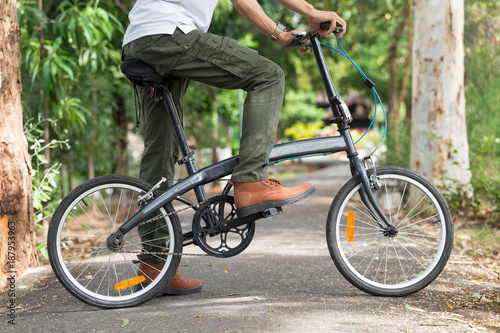 Man with cargo pants riding a bicycle in the garden