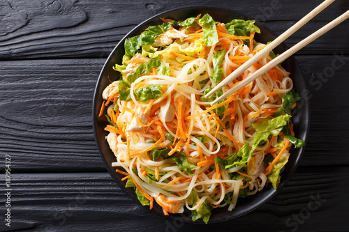 Vietnamese chicken salad with rice noodles, carrots and herbs macro. horizontal top view