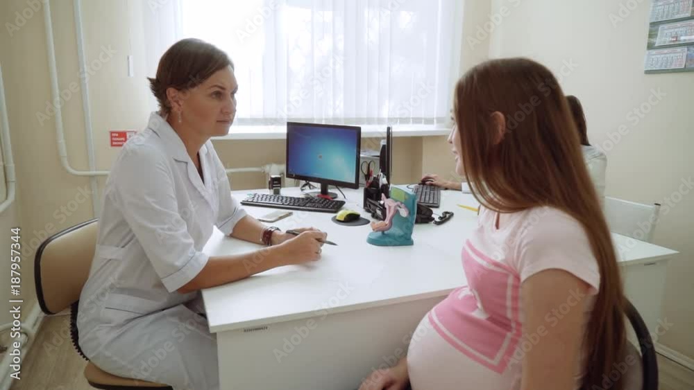 Happy beautiful young pregnant girl in the office at a doctor's reception. Happy beautiful young pregnant girl in the office at a doctor's reception.