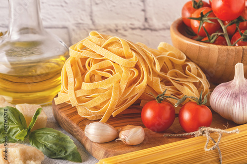 Products for cooking - pasta, tomatoes, garlic, olive oil, basil.