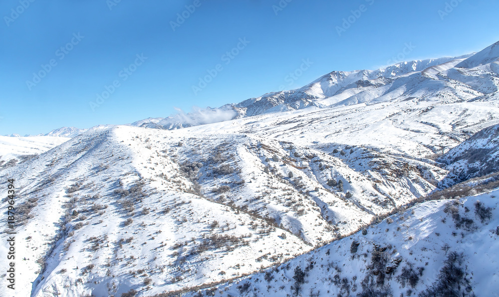 Obraz premium Clouds on snow-capped mountains