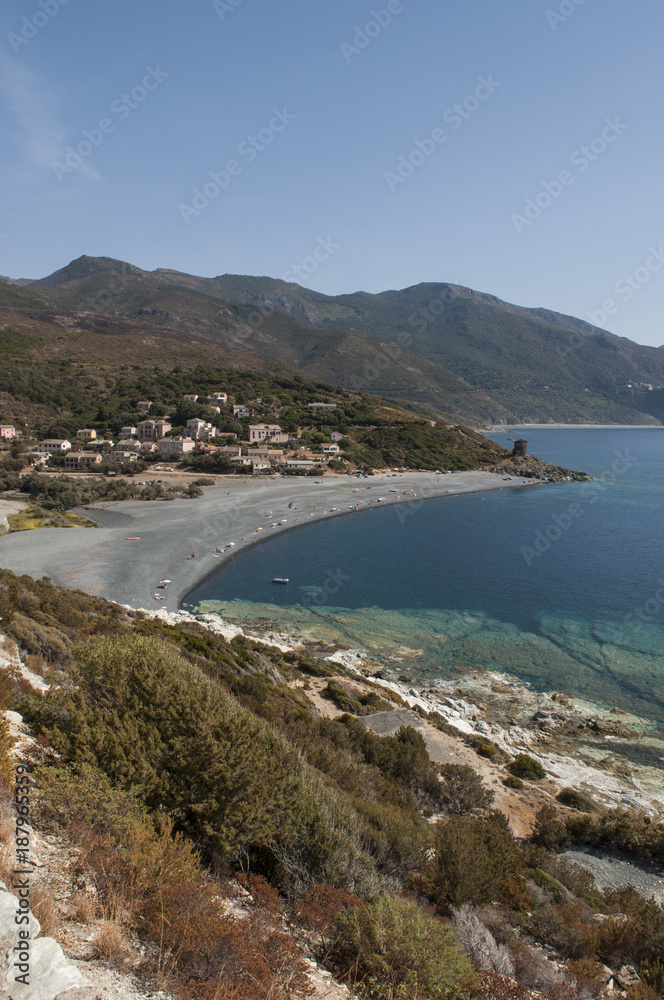 Corsica, 28/08/2017: la strada tortuosa del versante ovest di Capo Corso, famoso per il suo paesaggio selvaggio, con vista su una delle tante spiagge nere sulla costa 