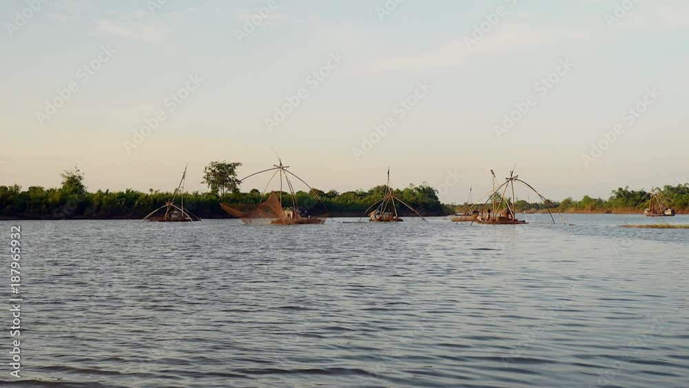 Houseboats on river and large fishing nets being lifted out of water ( shooting from a boat) Houseboats on river and large fishing nets being lifted out of water ( shooting from a boat)