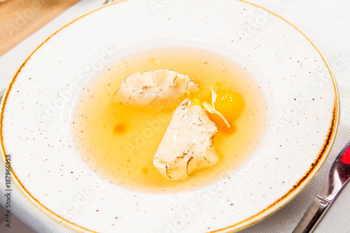 Dumplings in broth with an egg yolk served in a restaurant