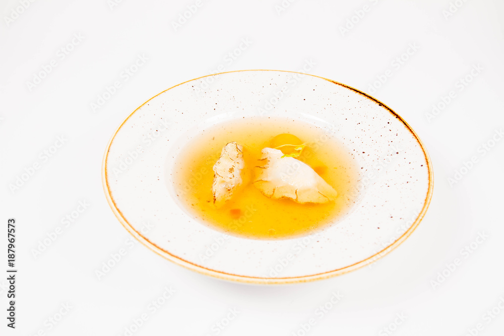 Dumplings in broth with an egg yolk on a white background Dumplings in broth with an egg yolk on a white background