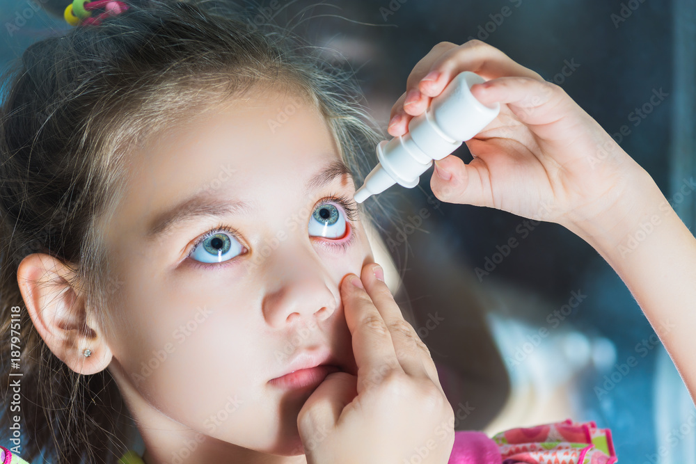 Beautiful child dripping in eye drops conjunctivitis Stock Photo