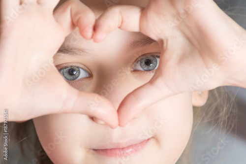 The beautiful eyes of the child in the hand heart