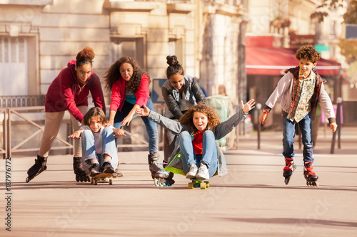 Teens having fun rollerblading and skateboarding