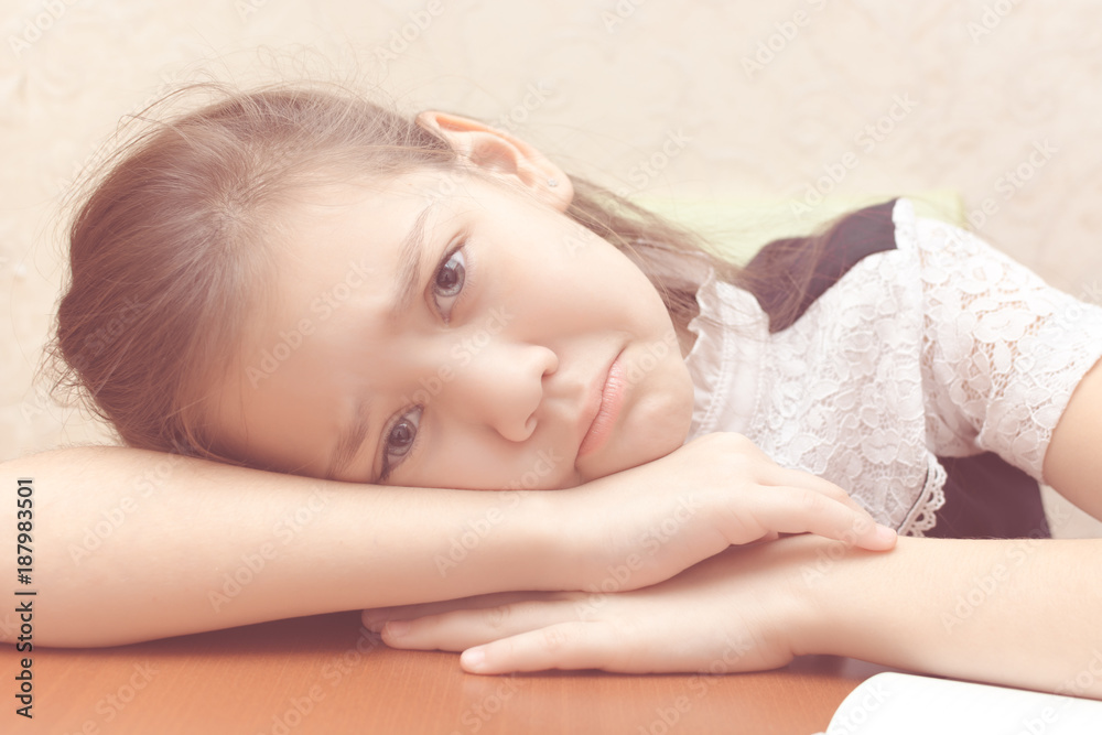 The tired girl lies on the table and sad The tired girl lies on the table and sad