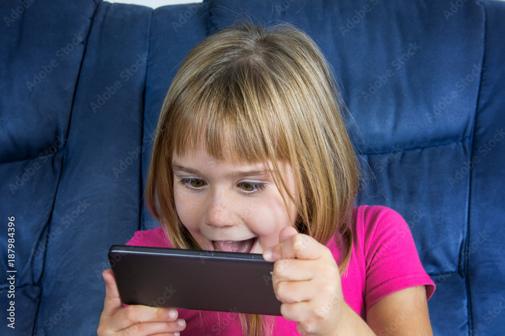 Little girl sitting and play game at mobile phone. Little girl sitting and play game at mobile phone.