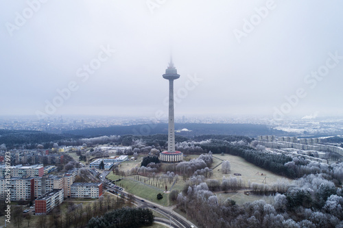 Aerial view over capital city Vilnius symbol TV Tower surrounded by old soviet time architecture in Karoliniskes district, Vilnius, Lithuania. During frosty winter daytime. photo