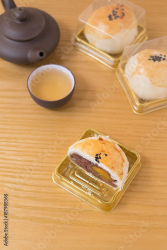 traditional chinese snack of preserved egg cakes with one cut out and cup of tea nearby