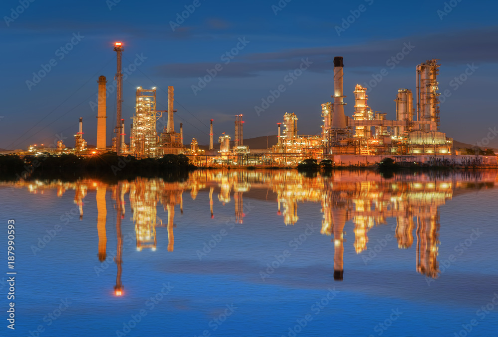 Obraz premium Oil refinery at twilight with reflection on water