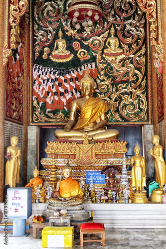 Golden buddha statue with diya lights.