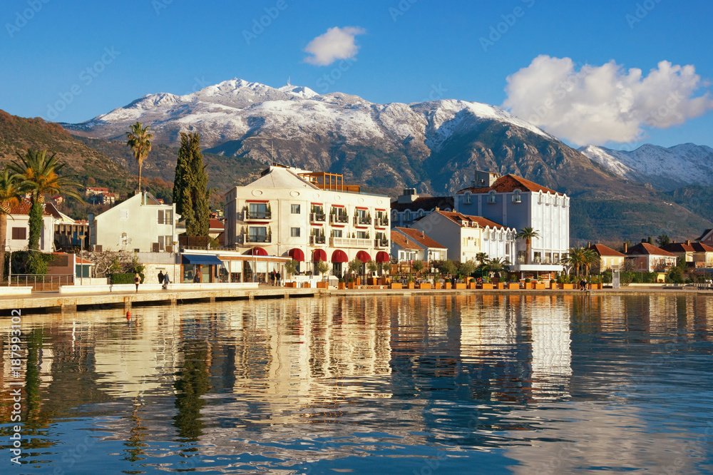 Winter Mediterranean landscape. Montenegro, embankment of Tivat city and snow-capped  Lovcen mountain