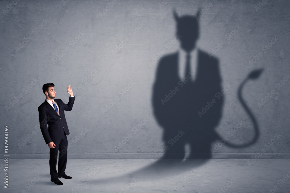 Fototapeta premium Business man looking at his own devil demon shadow concept