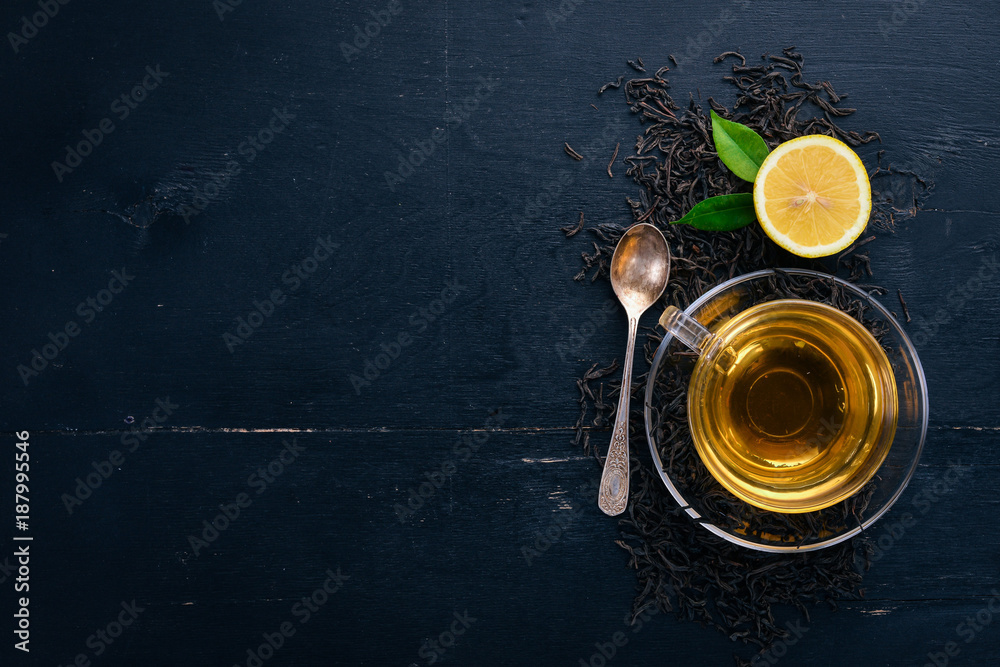 Tea in a glass cup with spices and herbs. On a black wooden background. Top view. Copy space.