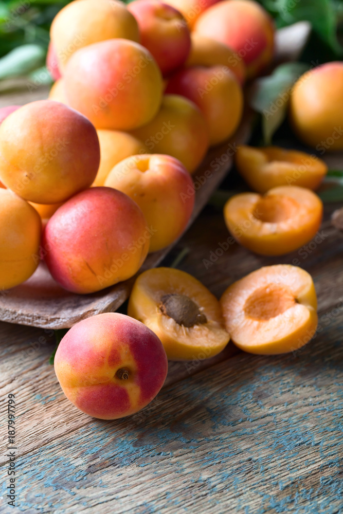 Juicy fresh apricots with leaves .