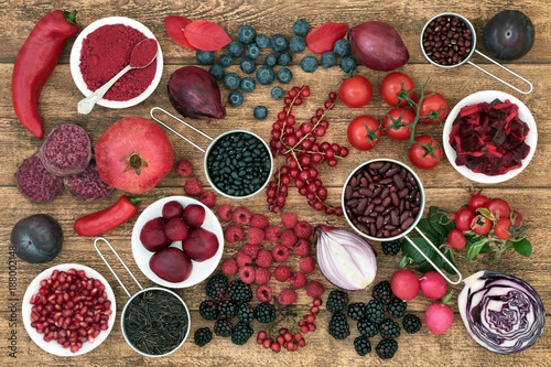 Health food with fruit, vegetables, grain and pulses high in anthocyanins, antioxidants, minerals and vitamins on rustic oak background. Healthy eating concept. Top view. photo