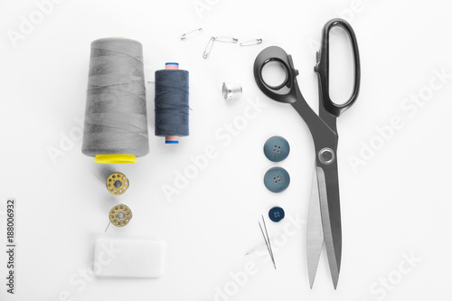 Composition with sewing threads and accessories on white background, top view photo