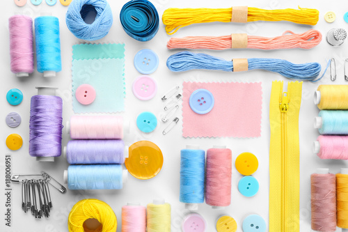 Composition with sewing threads and accessories on white background, top view photo