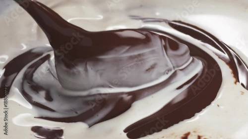 Slow motion closeup mixing liquid cream with dark chocolate photo