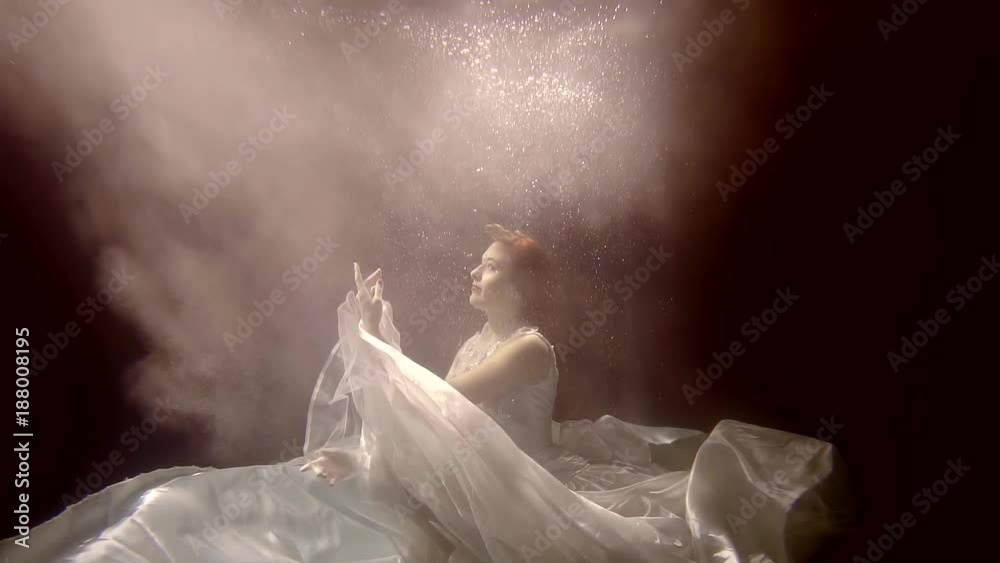 woman in a white dress, bathes in the water, she dived to the bottom of the pool woman in a white dress, bathes in the water, she dived to the bottom of the pool