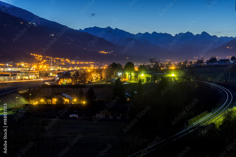 Italian city at blue hour with mountains on background