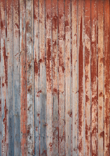 The texture of a wooden fence with a shabby red paint.