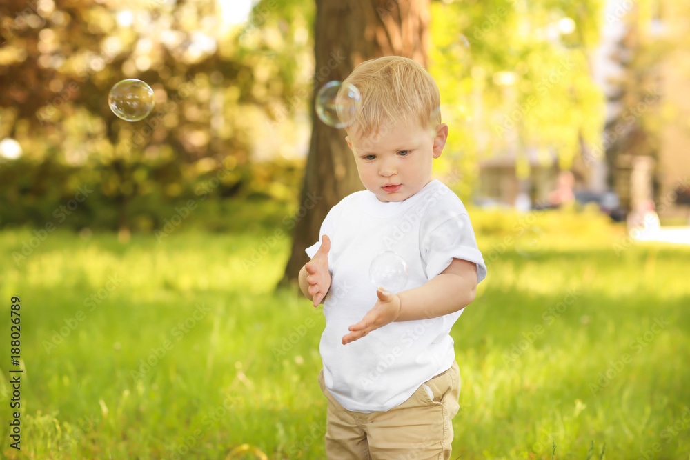 Cute baby boy walking in green park on sunny day Cute baby boy walking in green park on sunny day
