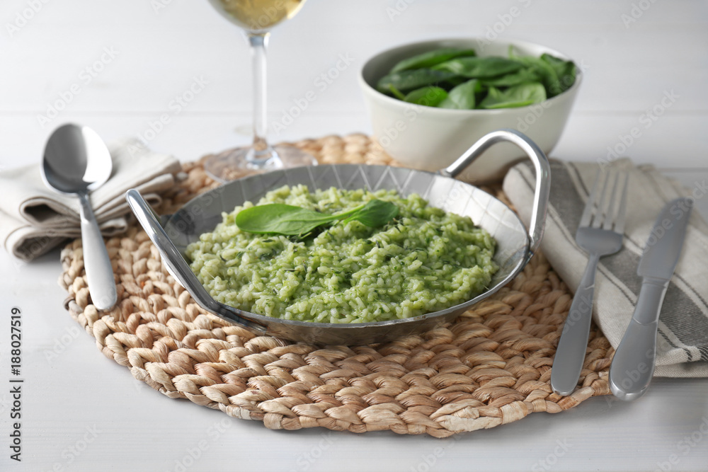Dish with delicious spinach risotto on wooden table Dish with delicious spinach risotto on wooden table