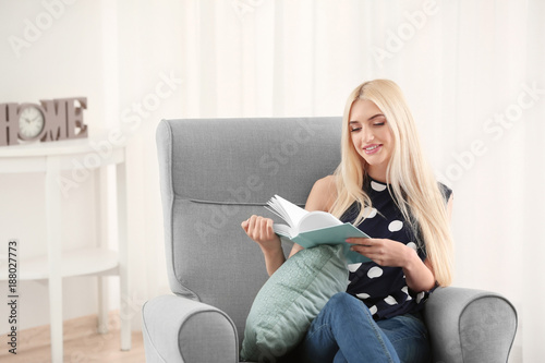 Beautiful smiling woman reading book at home
