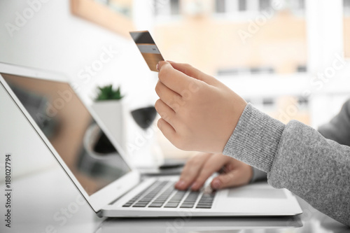 Woman using laptop while ho...
