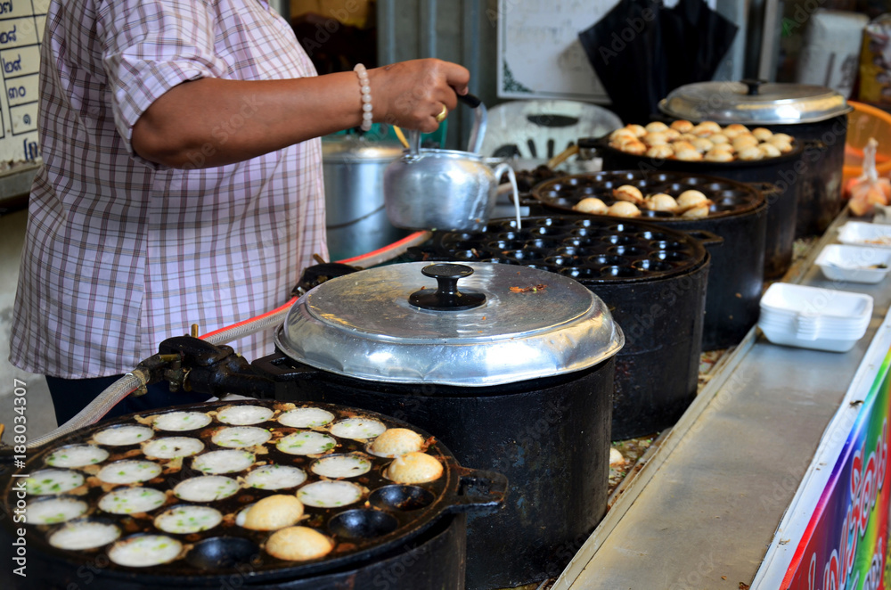 Thai people cooking thai snack Khanom Khrok is coconut milk mix with powder fried on pancake griddle