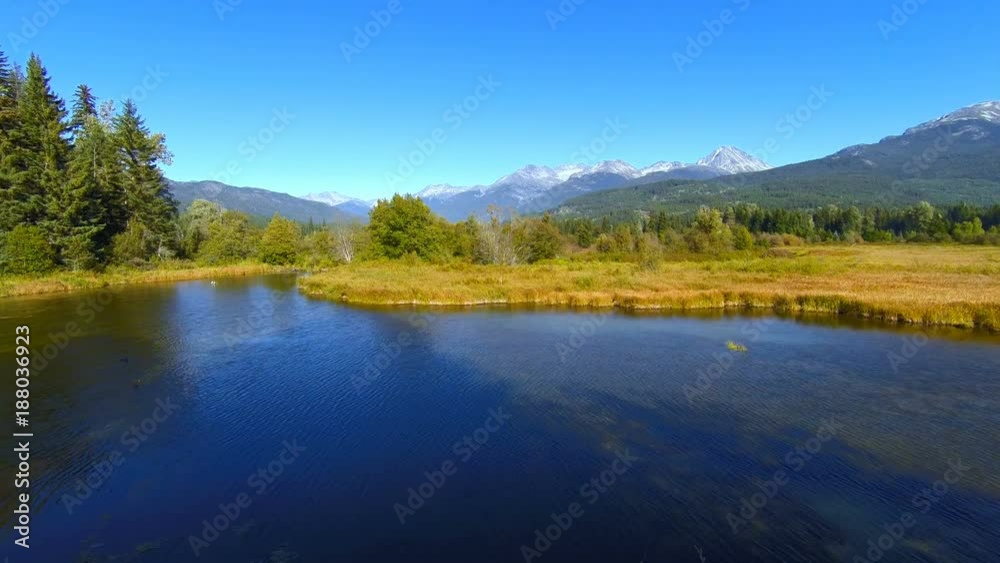 4K aerial nature flythrough of Canadian mountains at dusk in summertime, no people, rugged mountain terrain. Through the fields and by the river. 4K aerial nature flythrough of Canadian mountains at dusk in summertime, no people, rugged mountain terrain. Through the fields and by the river.