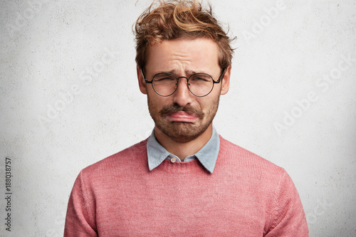 Canvas Print Bewildered displeased sorrorful man going to cry as sees no way out in difficult
