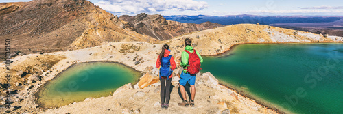 New Zealand volcanic mountain landscape in Tongariro Alpine Crossing National Park. Young people couple hikers tramping in NZ travel adventure, panoramic banner background. photo
