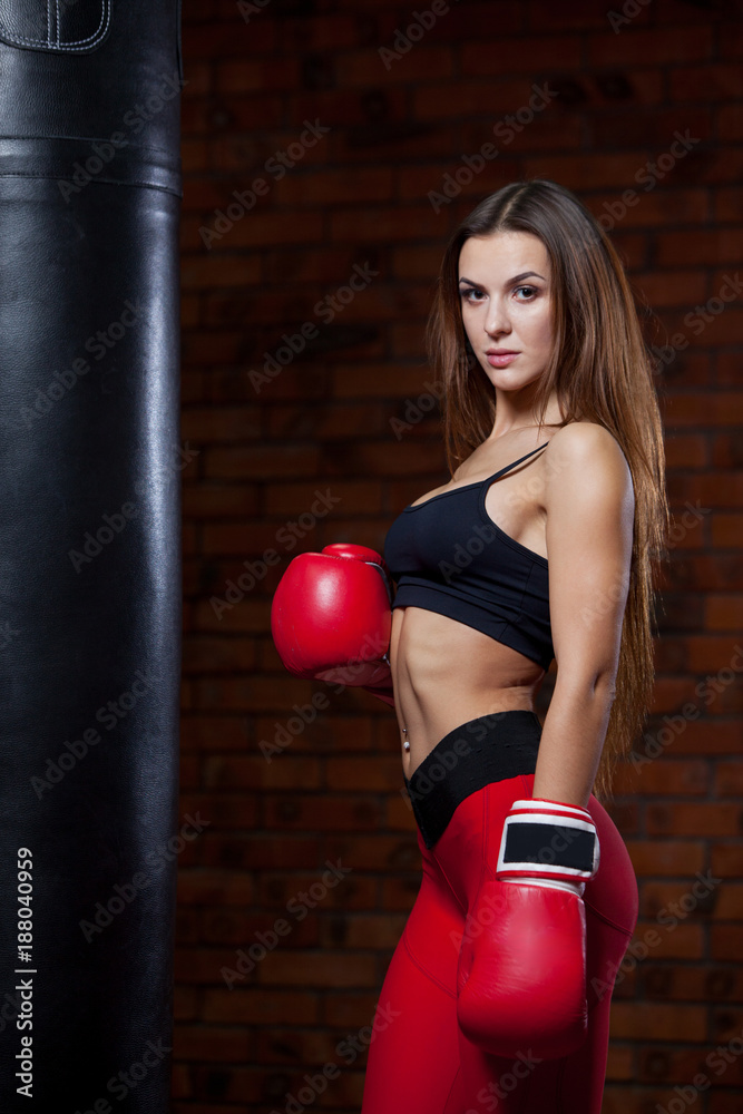 Young sexy woman with a punching bag in a gym
