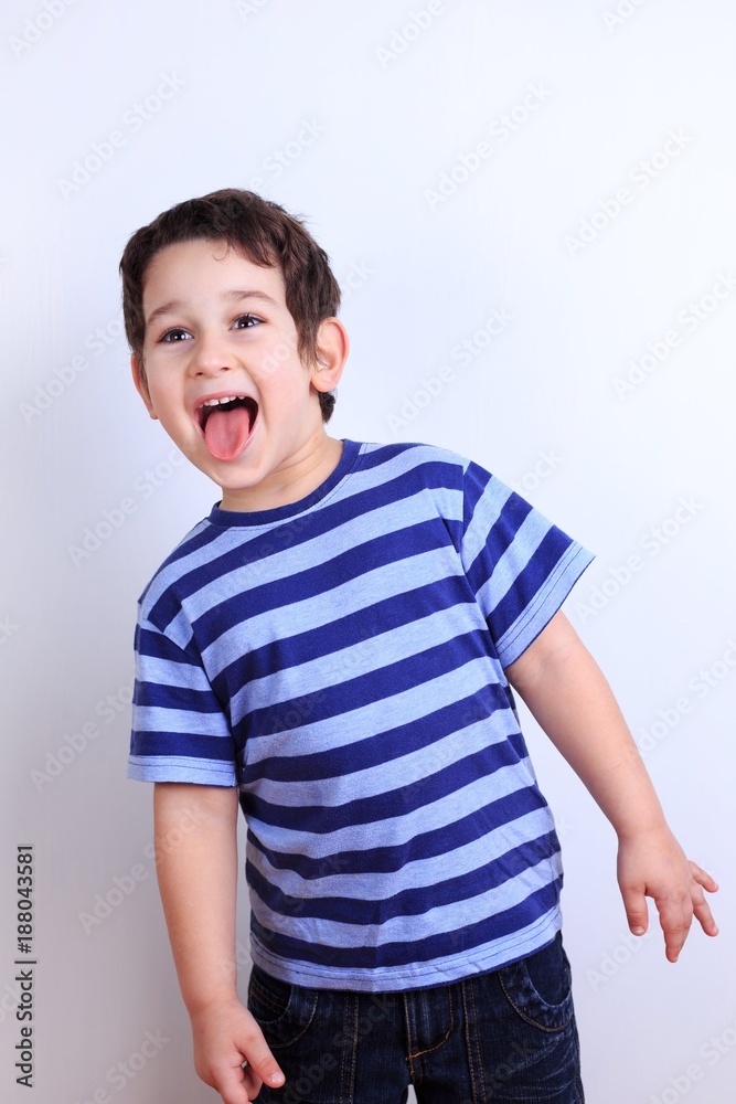 Naughty little boy showing tongue, close up studio shoot on white. Emotions, feelings, states of mind, childhood concept Naughty little boy showing tongue, close up studio shoot on white. Emotions, feelings, states of mind, childhood concept