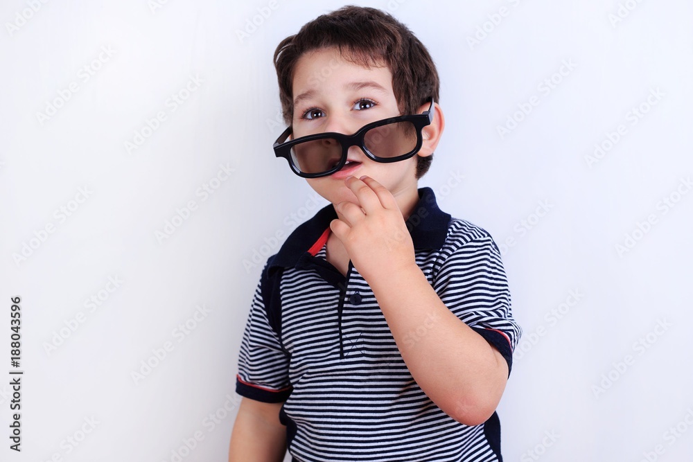 Funny photo of cute little boy putting on sunglasses, studio shoot on white. Lifestyle, children concept Funny photo of cute little boy putting on sunglasses, studio shoot on white. Lifestyle, children concept