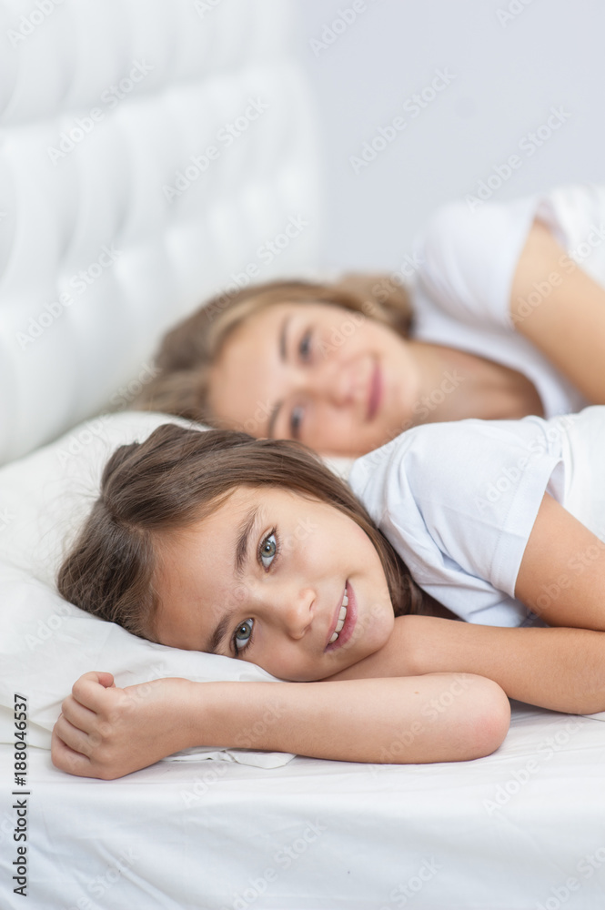 Mom and daughter lying together on the bed in the bedroom Mom and daughter lying together on the bed in the bedroom