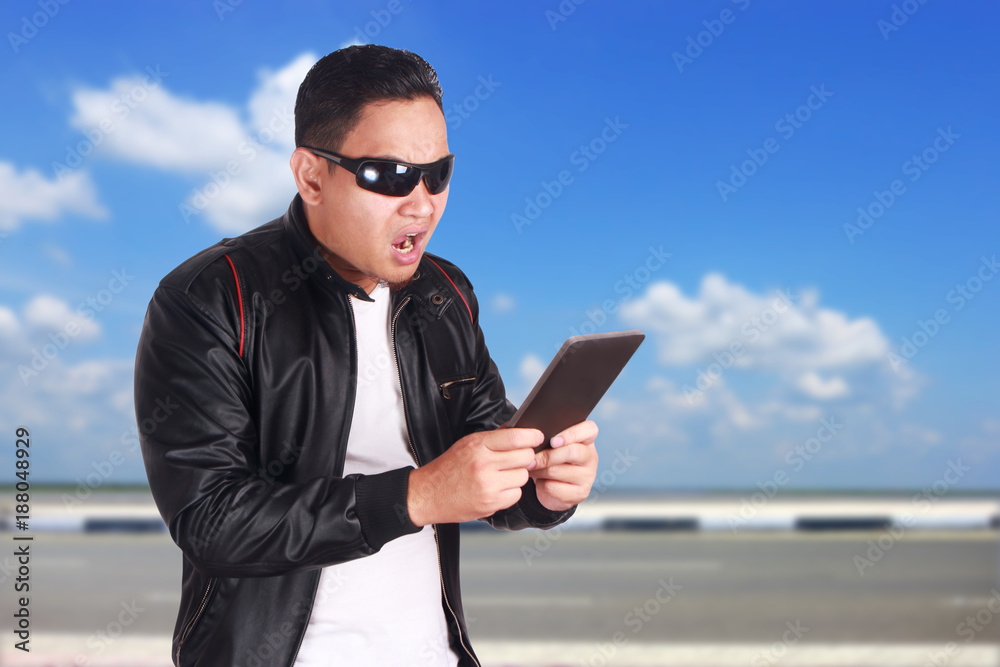 Asian Man Having Surprising News on Tablet