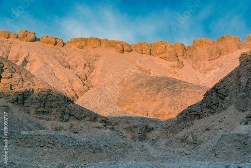 Desert hillside with stones in the Valley of the Kings in Egypt with a blue sky and a few clouds