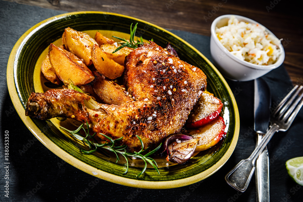 Roast chicken leg with chips on wooden background Roast chicken leg with chips on wooden background