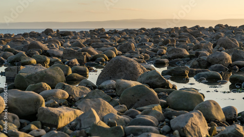 The stones of Llantwit Major Beach in the evening sun, South Glamorgan, Wales, UK