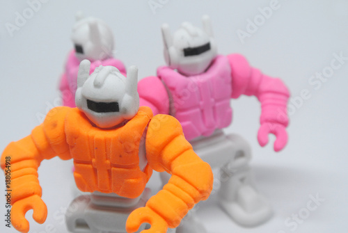Orange and pink small toy robot made from eraser rubber isolate on white background.